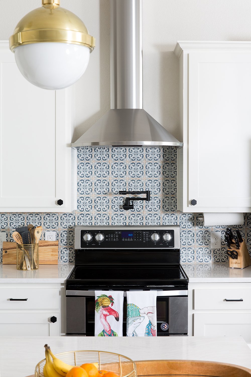 A modern farmhouse blue and white kitchen with Moroccan tile backsplash by Lesley Myrick Interior Design.