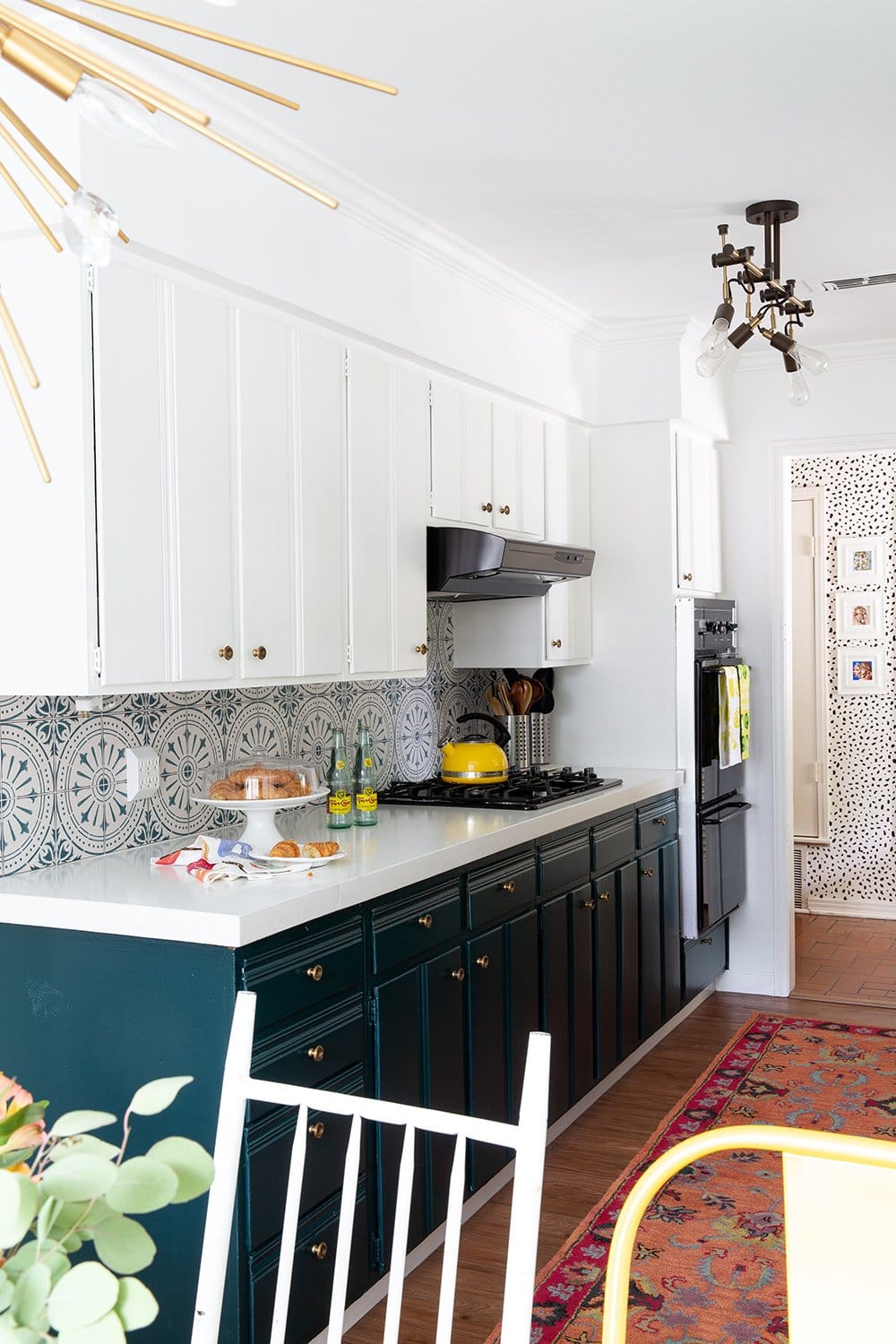 a bright kitchen with teal cabinets, mismatching tile backsplash