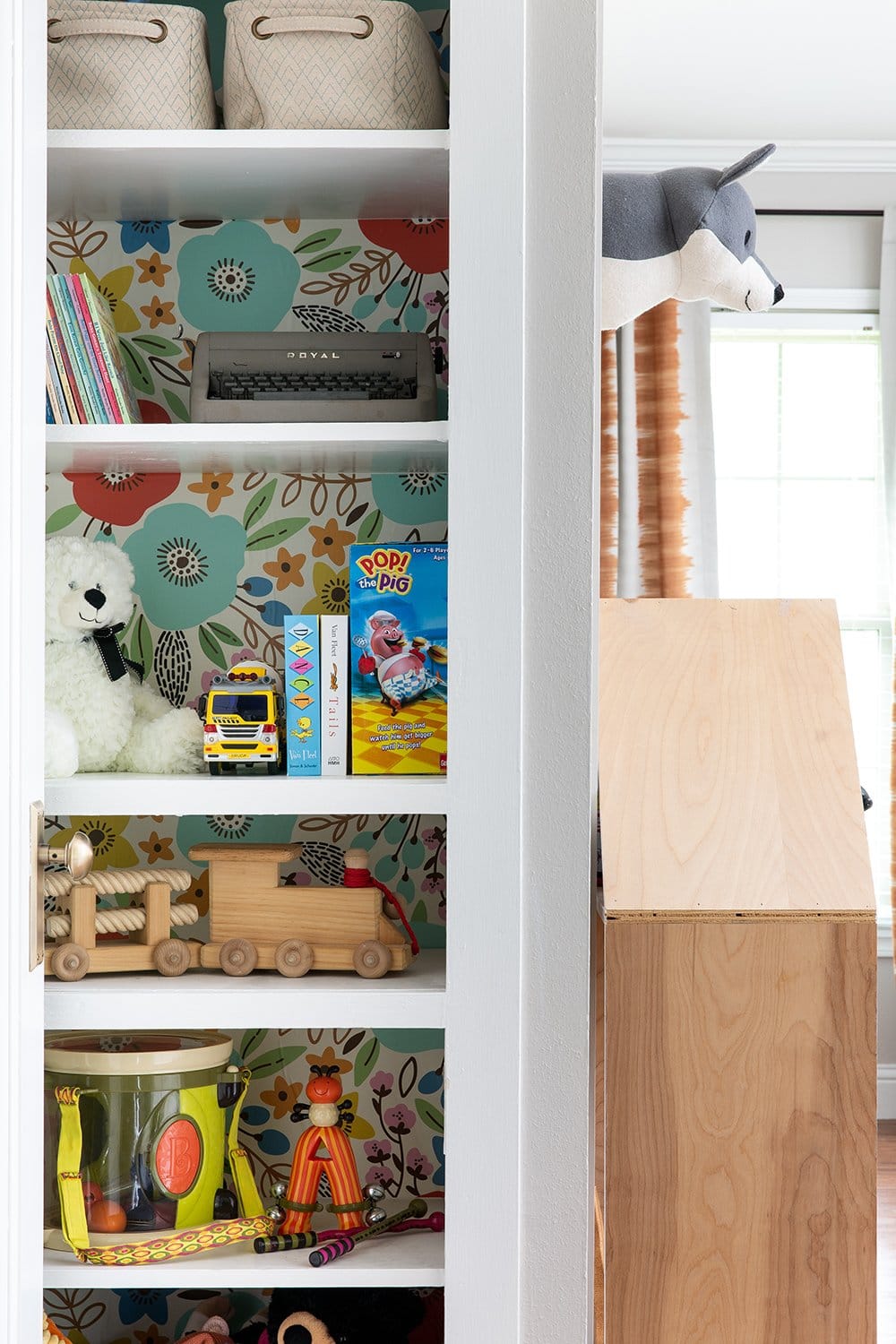 A built-in bookshelf with wallpaper by interior designer Lesley Myrick