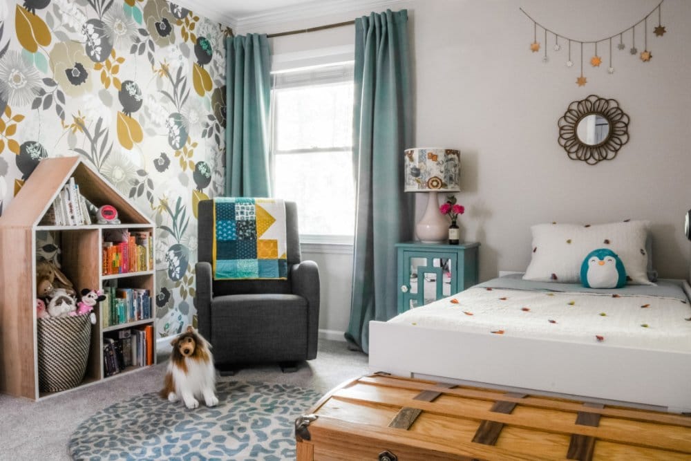 A colorful bedroom for a toddler with wallpaper