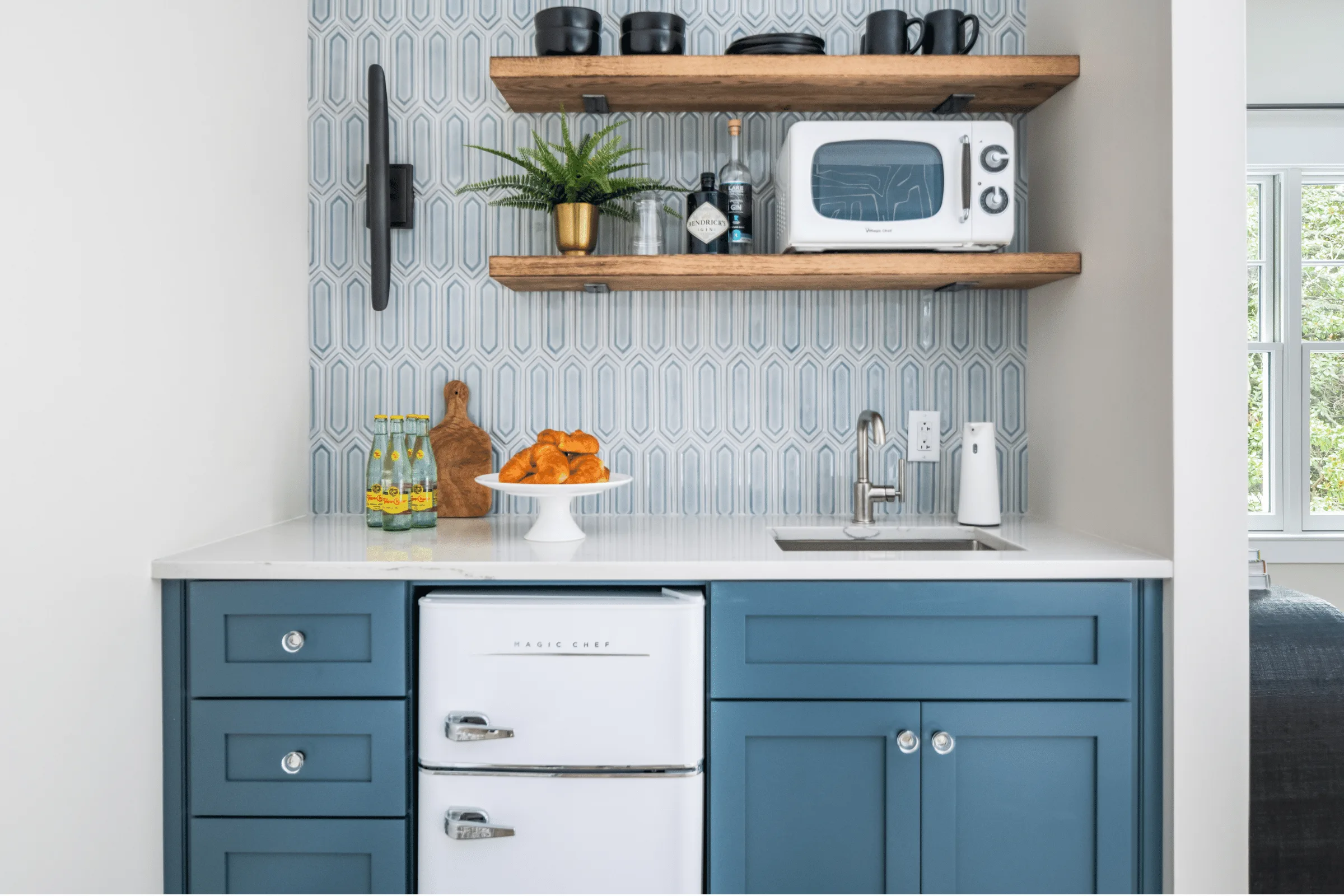 A modern kitchen featuring blue cabinets and a sleek refrigerator, creating a stylish and inviting atmosphere.