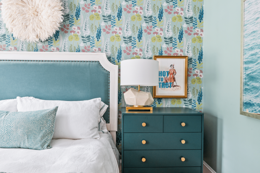 Teal floral wallpaper, a custom teal velvet bed, faceted table lamps, and a custom lumbar pillow in Kravet fabric in this bedroom by Lesley Myrick Interior Design.