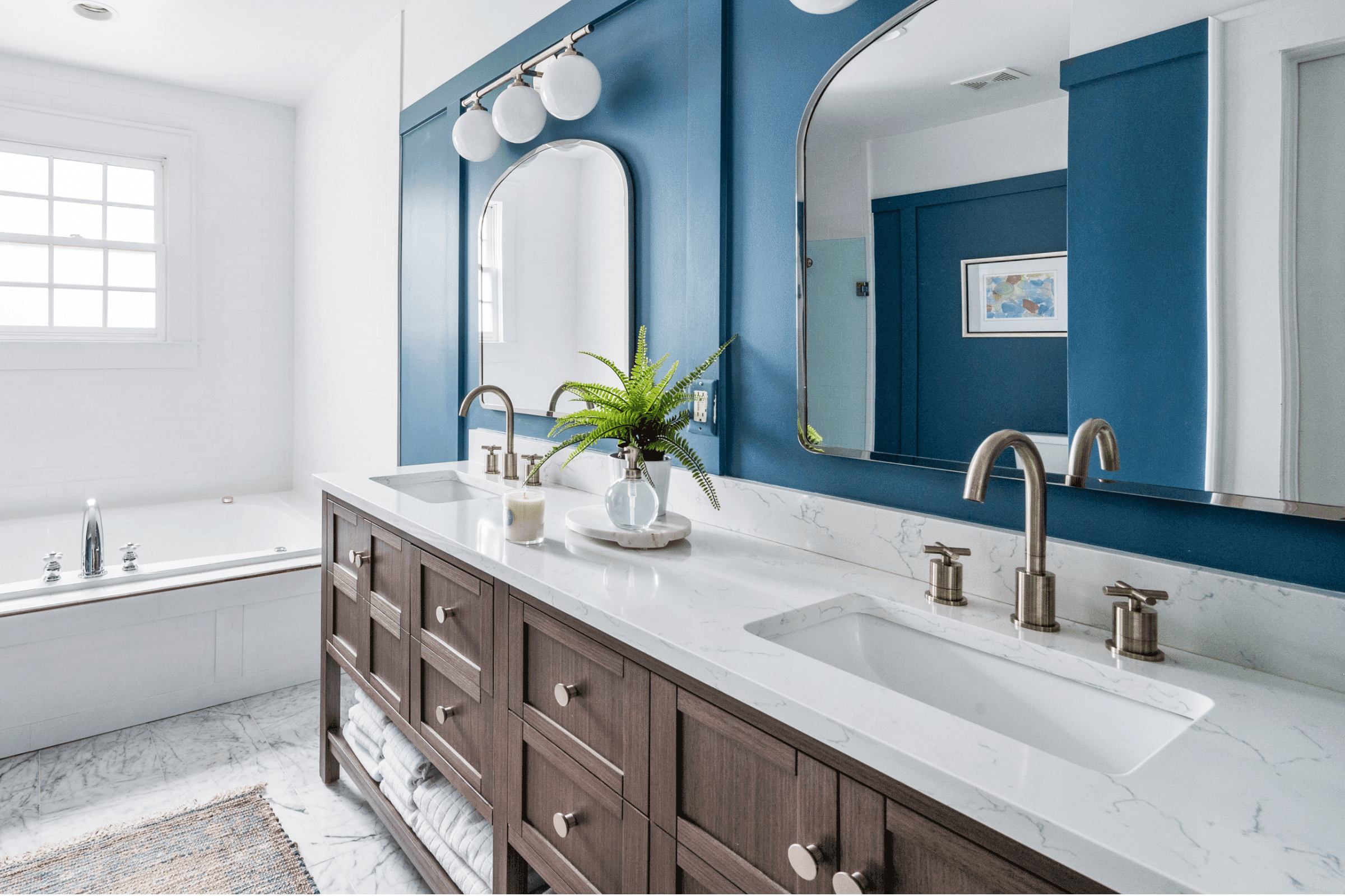 A bathroom featuring blue walls and white countertops, creating a serene and modern atmosphere.