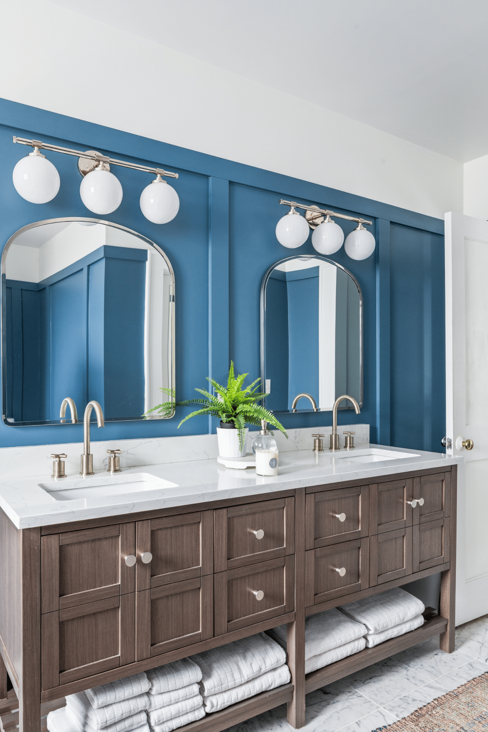 A luxe dark blue and white primary bathroom in Macon, GA, designed by Lesley Myrick Interior Design