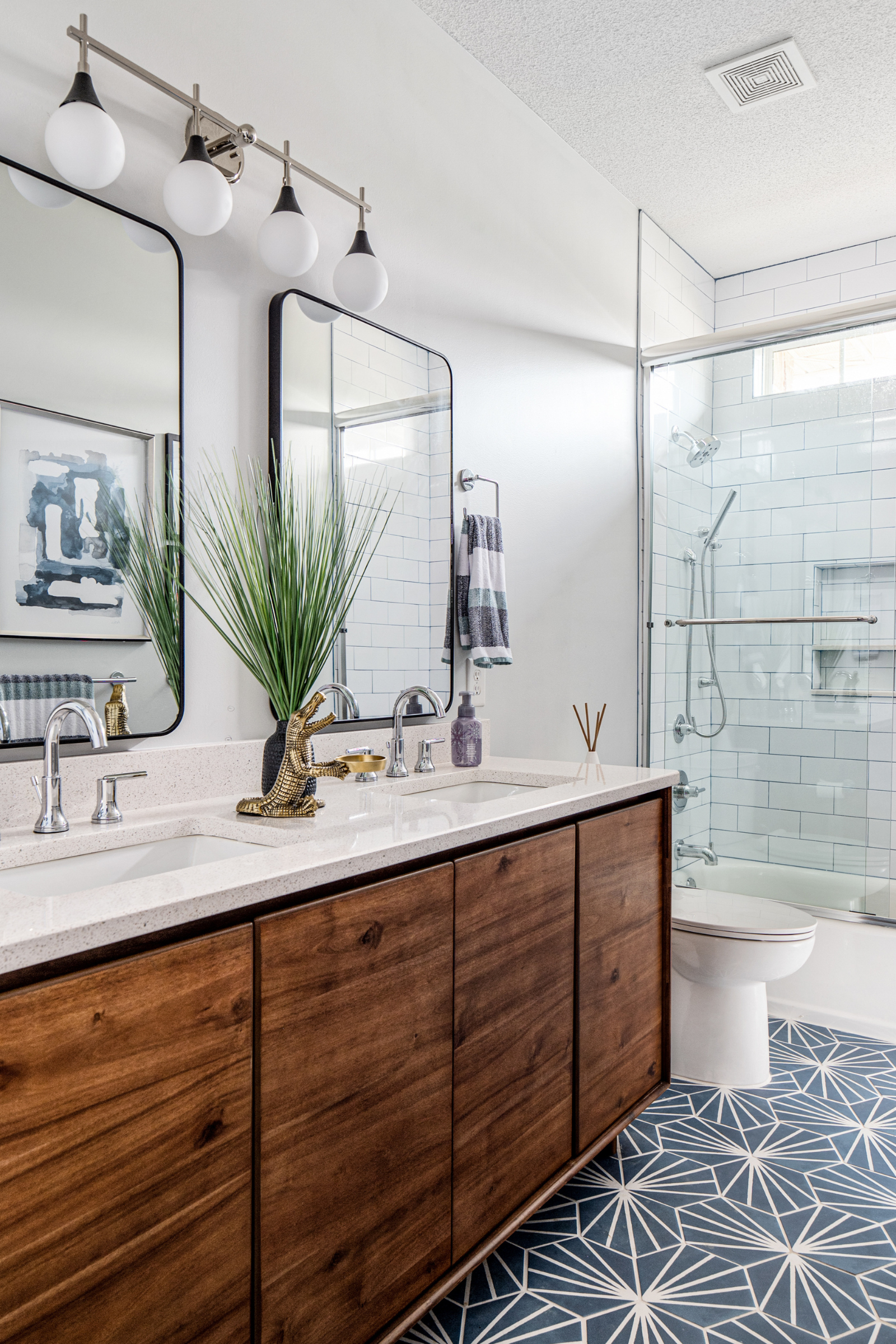 Mid-century wood vanity and hexagon tiles in a blue and white bathroom remodel