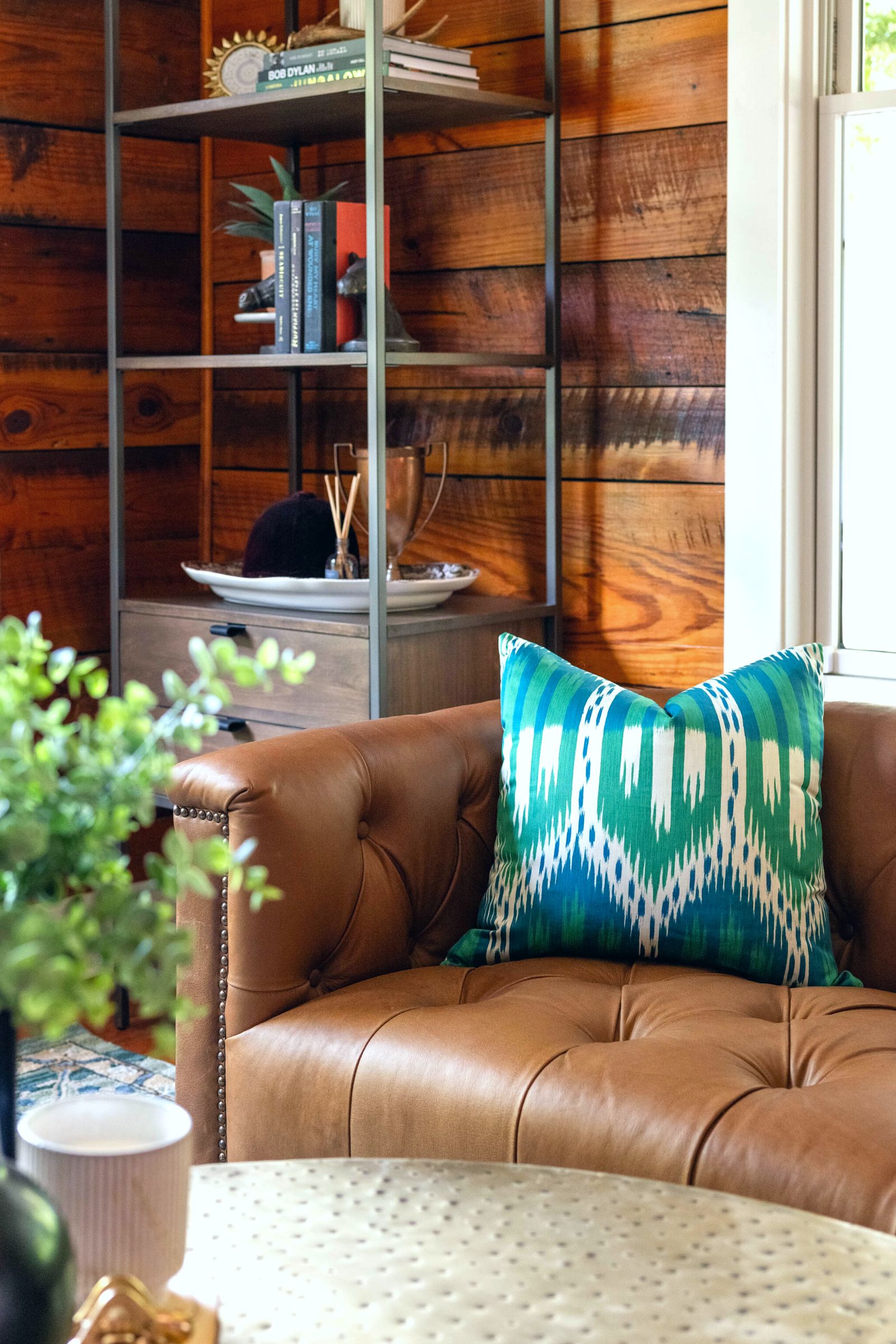 Brown leather tufted sofa with green Ikat accent pillow by Lesley Myrick Interior Design