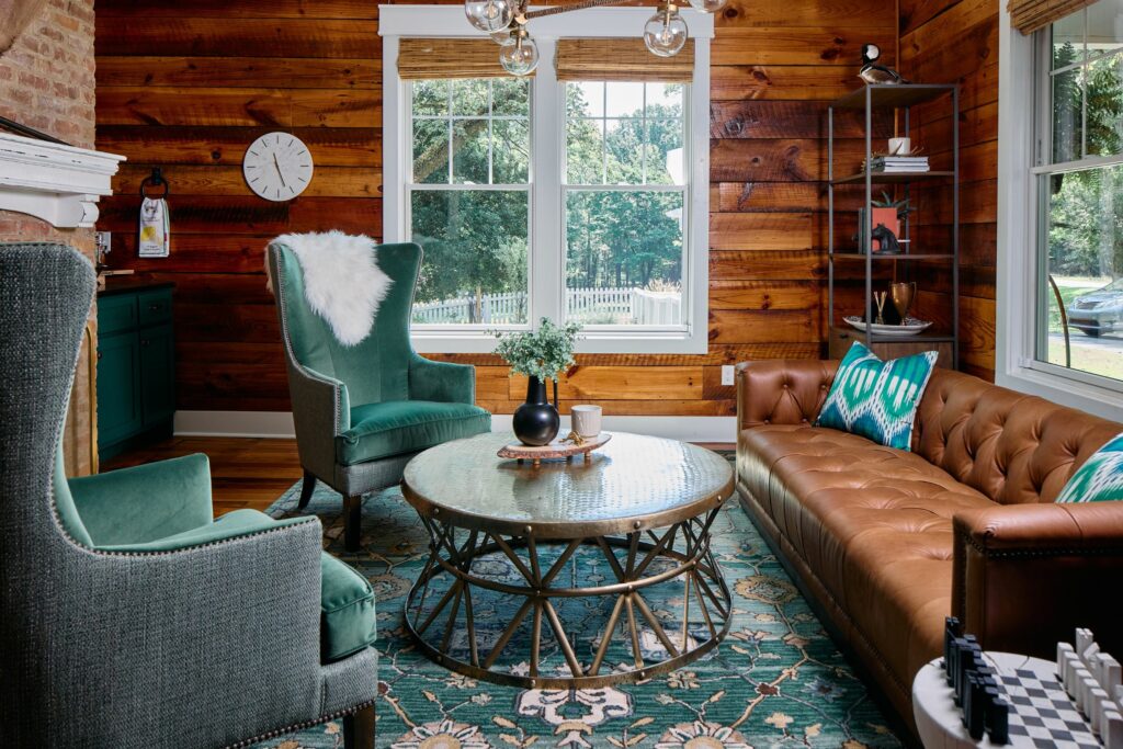 Farmhouse lounge design with green velvet wing chairs by Lesley Myrick Interior Design