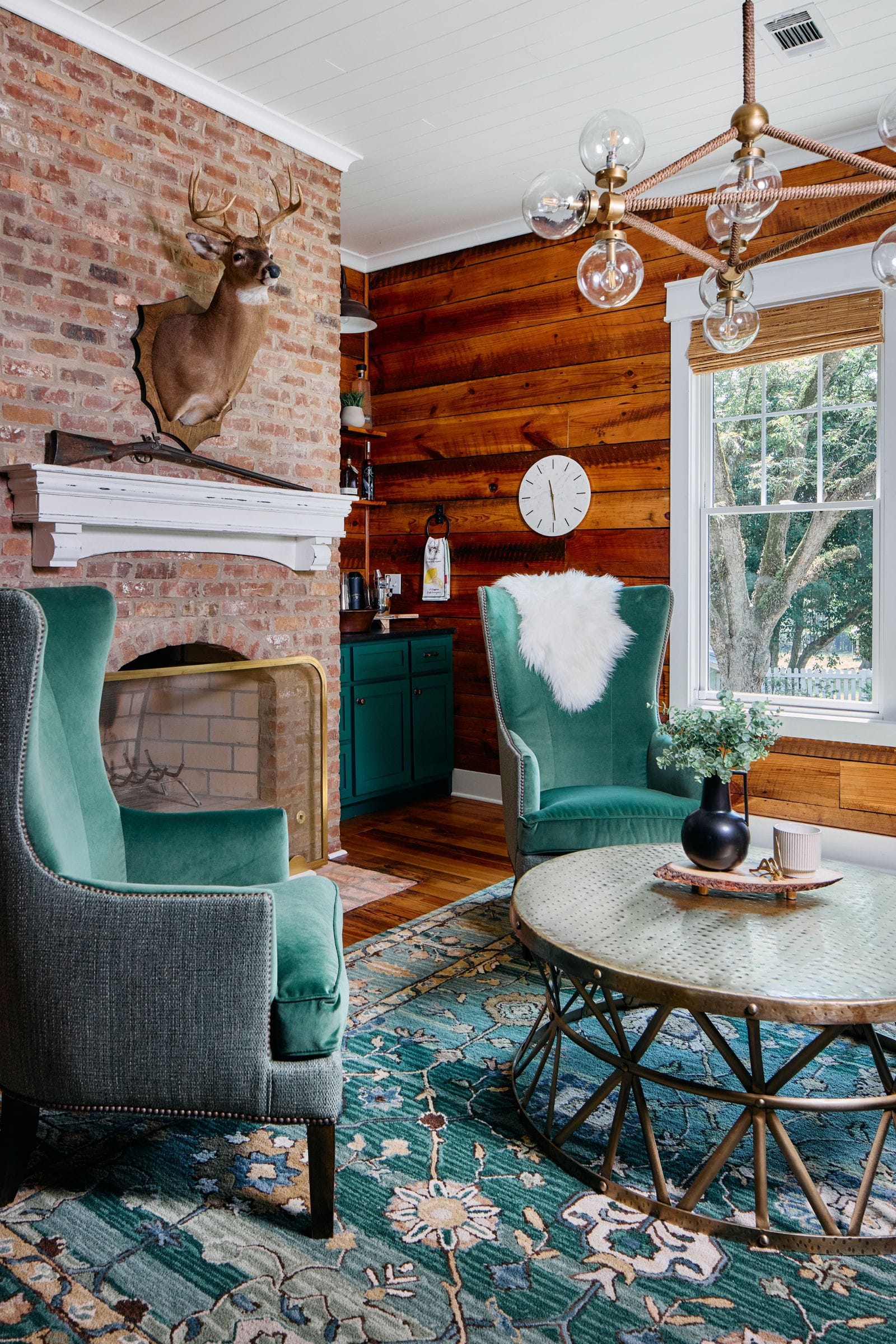 Farmhouse lounge design with green velvet wing chairs by Lesley Myrick Interior Design