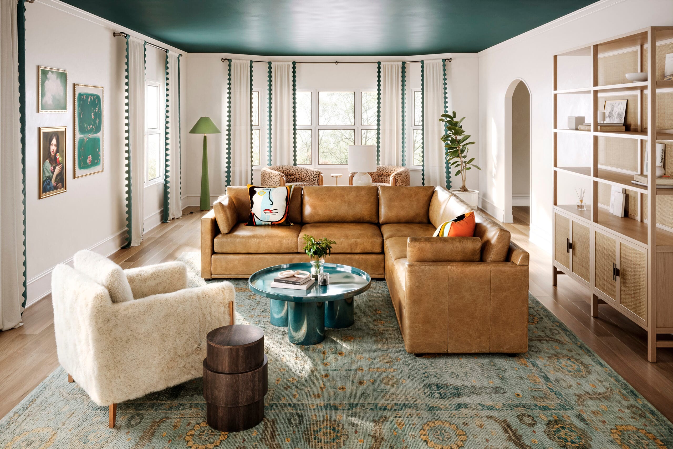 A long narrow living room is a serious design challenge! Lesley Myrick decorated this living room using area rugs to define areas, floating the furniture away from the walls, and using design elements to draw the eye upwards.
