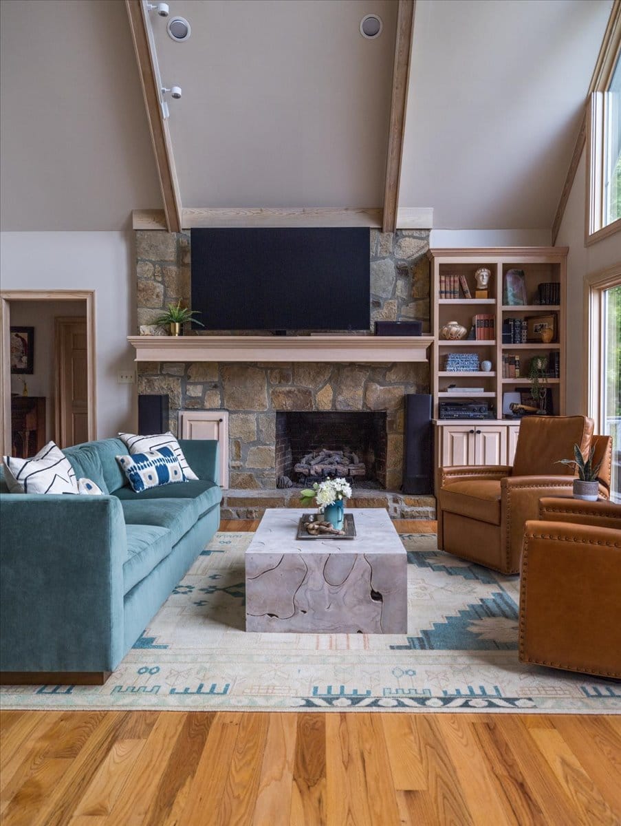 Close-up side view of living room with velvet sofa, fireplace, and built-ins.