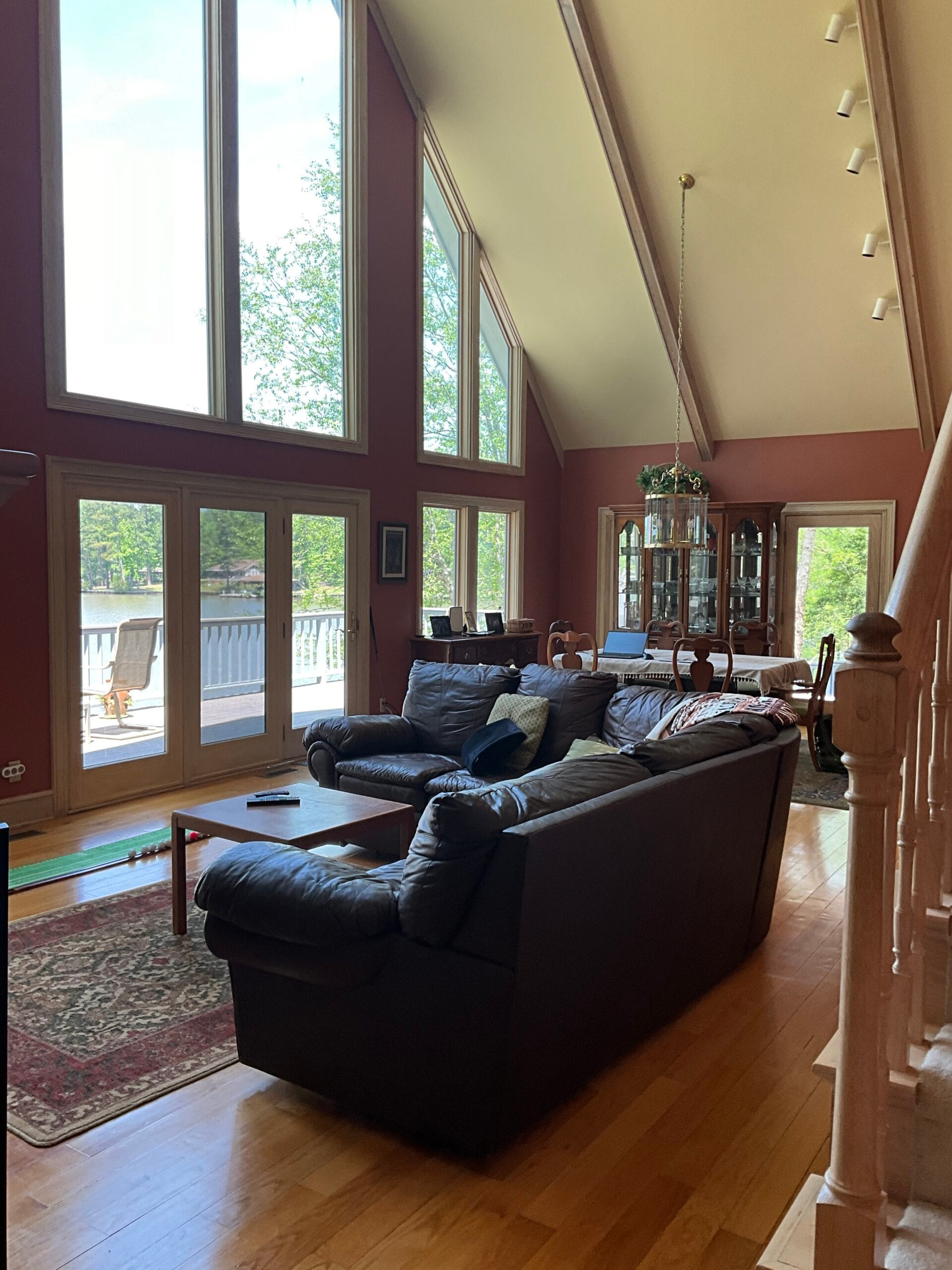 Dining room before renovation with traditional wood furniture and red walls at Lake Sinclair home.