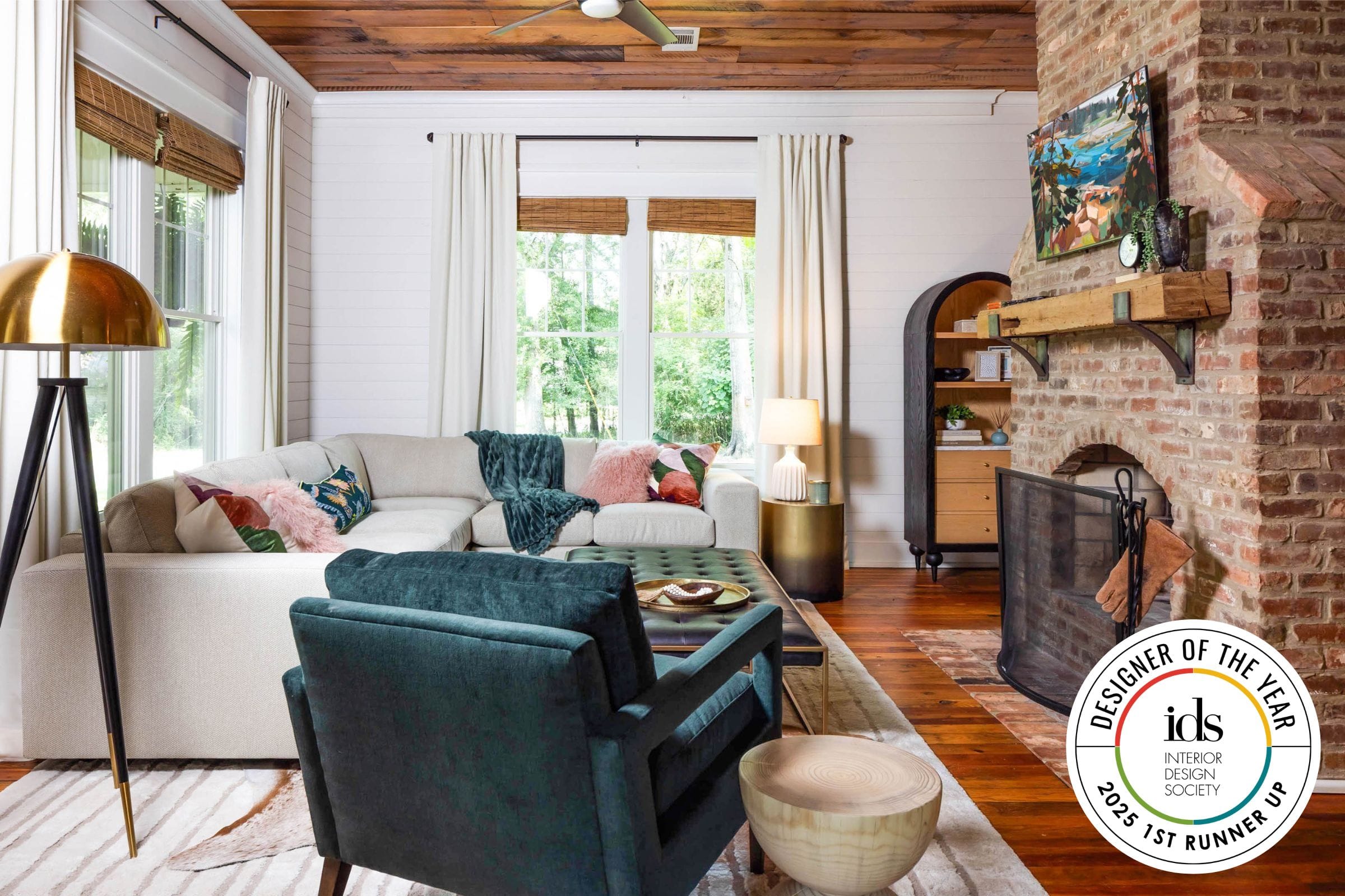 The living room of Lesley Myrick's Designer of the Year award-winning Forsyth Farmhouse project with original freestanding brick fireplace