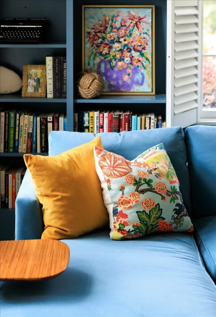 Colorful pillows and art complement a teal sofa in this living room by Interior Designer Lesley Myrick.