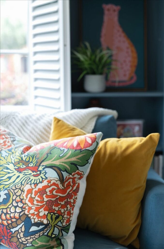 Colorful pillows anchor a teal sofa in this living room by Interior Designer Lesley Myrick.