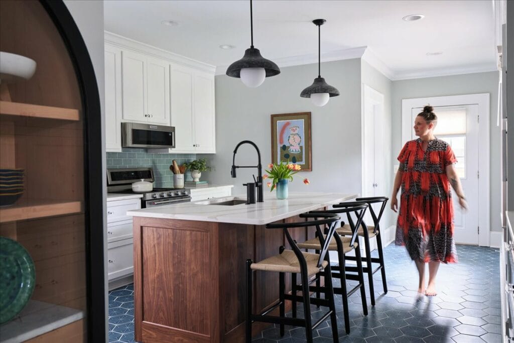 A contemporary kitchen in Macon, GA, by Interior Designer Lesley Myrick features blue hex tiles on the floor, a custom walnut island, and blue-green backsplash tile.