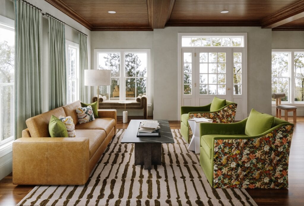 A 3D rendering for the living room of a full-service interior design project. It features floral velvet, black marble, hammered brass, and walnut.