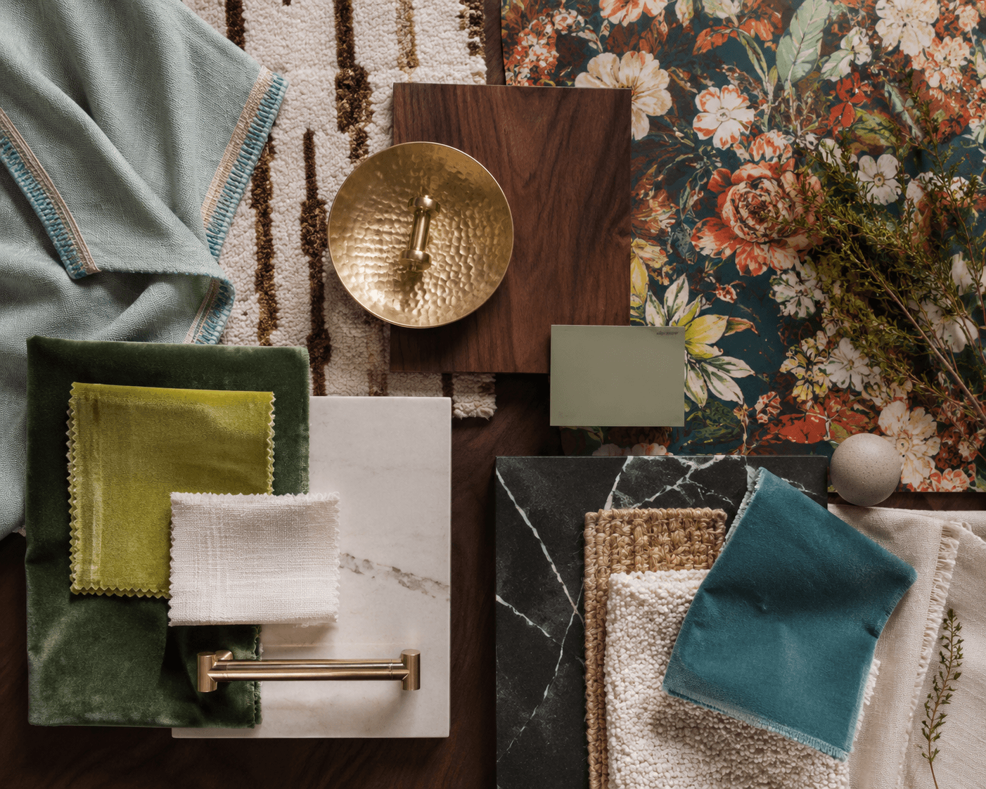 A materials flat lay for the living room of a full-service interior design project. It features floral velvet, black marble, hammered brass, and walnut.